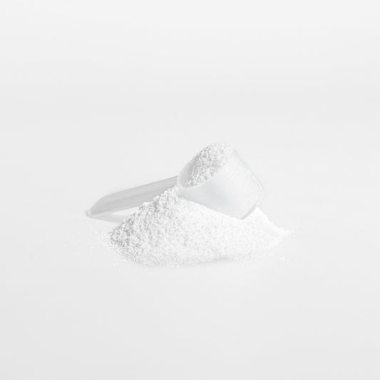 White powder in a measuring spoon on a white background