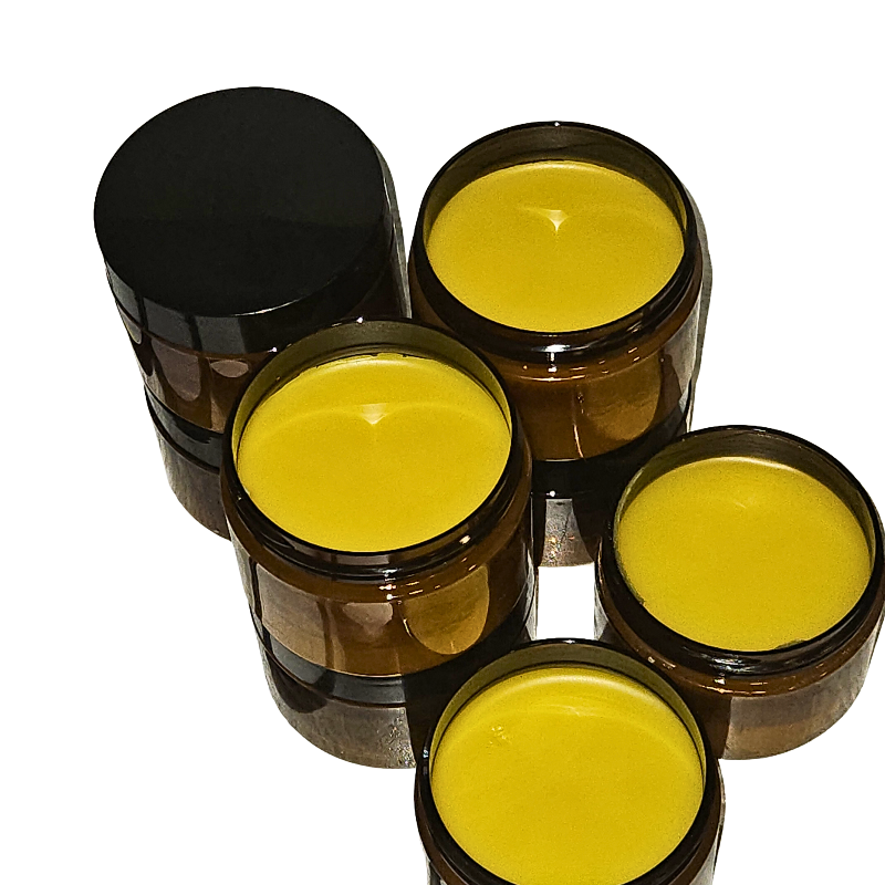 Five brown jars with black lids containing a yellow substance on a white background
