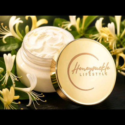 HoneySuckle Whipped Butter in a clear container signature gold lid and logo on a HoneySuckle flower filled background 