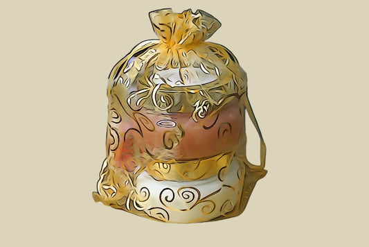 Spa Gift Set wrapped in gold paper on a reflective surface