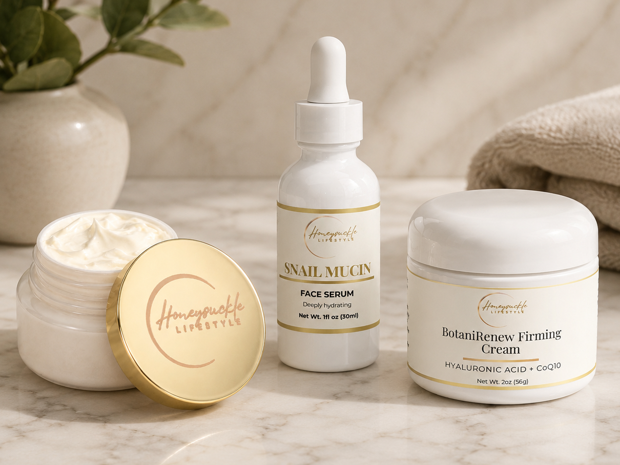 Skincare products including a face serum, cream, and dropper bottle on a marble surface with a plant and towel in the background.