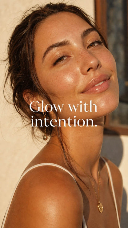 Woman with a radiant smile and text 'Glow with intention' on a neutral background